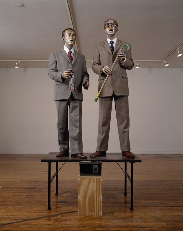 [[#Gilbert και George [Γκίλμπερτ και Τζωρτζ]#]], Singing Sculpture [Άδουσα γλυπτική, 1970]. Για αυτή την περφόρμανς, οι δημιουργοί κάλυψαν τα κεφάλια και τα χέρια τους με πολύχρωμες μεταλλικές σκόνες, στάθηκαν πάνω σε ένα τραπέζι και τραγουδούσαν, ενώ παράλληλα κινούνταν στον ρυθμό της ηχογράφησης του τραγουδιού των Flanagan and Allen «Underneath the Arches», μερικές φορές ακόμη και για ολόκληρη ημέρα. Οι στολές που φορούσαν στην επιτέλεση αυτή μετατράπηκαν στη συνέχεια σε ένα είδος προσωπικής τους «στολής». Σπάνια εμφανίζονταν δημόσια χωρίς να τις φορούν.