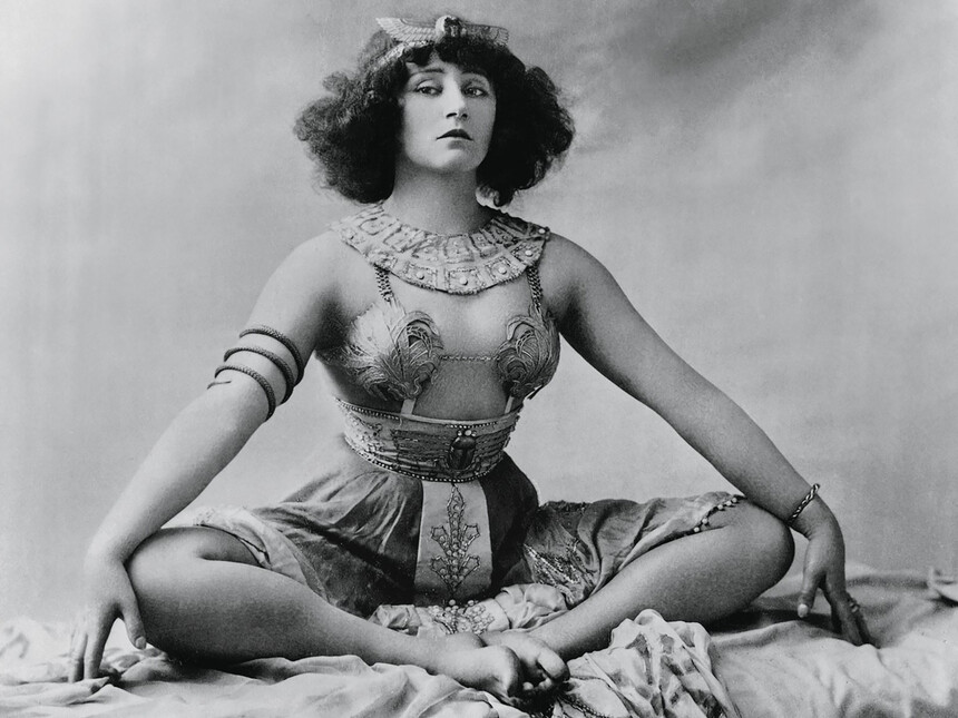 Η Colette [Κολέτ] στο μιμόδραμα Rêve d'Égypte [Όνειρο της Αιγύπτου], Moulin Rouge [Μουλέν Ρουζ], Παρίσι, Ιανουάριος 1907. Η παράσταση αξιοποίησε τη δραματουργία της σταδιακής σωματικής αποκάλυψης, λειτουργώντας ως πρόδρομη, οριακή μορφή στριπτήζ στο χώρο του παρισινού καμπαρέ. Φωτογραφία: Léopold Reutlinger [Λεοπόλντ Ρέτλινγκερ], περ. 1907.