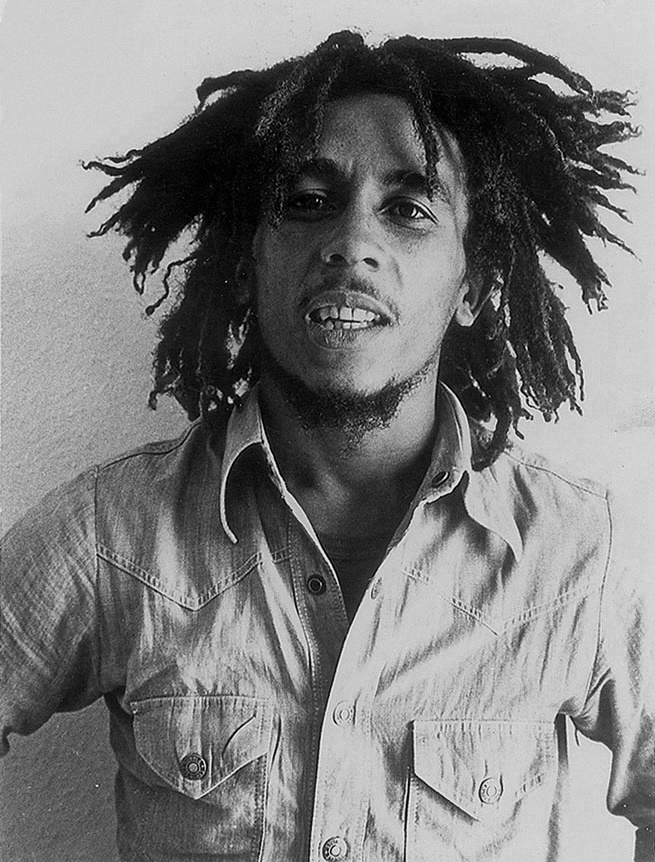 O [[#Bob Marley [Μπομπ Μάρλεϋ]#]] (1945-1981), η φωνή που καθιέρωσε το τζαμαϊκανό ρέγκε ως παγκόσμιο ιδίωμα με μηνύματα ειρήνης και κοινωνικής δικαιοσύνης, σε φωτογραφία τύπου του 1976. Το τραγουδιστικό του ύφος συνδυάζει τη ρητορική παράδοση του κηρύγματος των Ρασταφάρι με τη φρασεολογία της αφροαμερικανικής σόουλ: μελωδική γραμμή που ακολουθεί τον ανάποδο τονισμό του ρυθμού, ρινική χροιά, μελίσματα μικρής έκτασης και διαρκής διάλογος της κύριας φωνής με τις γυναικείες φωνές των I Threes. Το τραγούδι λειτουργεί εδώ ταυτόχρονα ως λατρευτική πράξη, ως αφήγηση και ως πολιτική διακήρυξη.
