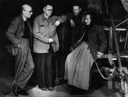 Ο [[#Bertolt Brecht [Μπέρτολτ Μπρεχτ]#]] (δεύτερος από αριστερά) με την [[#Helene Weigel [Χέλενε Βάιγγελ]#]] κατά τις πρόβες της παράστασης Η Μάνα Κουράγιο και τα παιδιά της στην αρχική/πρώτη παραγωγή του [[#Berliner Ensemble [Μπερλίνερ Ανσάμπλ]#]]. Ανατολικό Βερολίνο, Deutsches Theater, 1949.&nbsp;