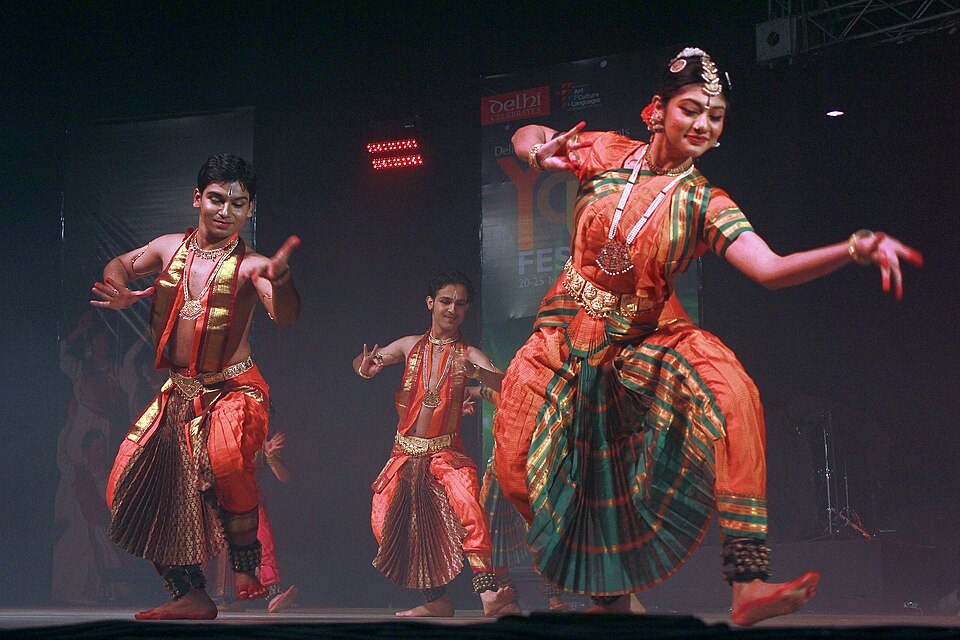 Επιτέλεση Μπαράτα Νάτυαμ [Bharatanatyam] από μαθήτριες της Σαρότζα Βαϊντυαναθάν [Saroja Vaidyanathan], 23 Νοεμβρίου 2012. Διακρίνεται η θεμελιώδης στάση αραμαντί [aramandi], με σταθερό άνω κορμό και ημικαθιστή θέση των σκελών, σε συνδυασμό με το κωδικοποιημένο λεξιλόγιο των χειρονομιών και της βλεμματικής έκφρασης. Φωτογραφία: [[#Σουμίτα Ρόι Ντούττα [Sumita Roy Dutta]#]].