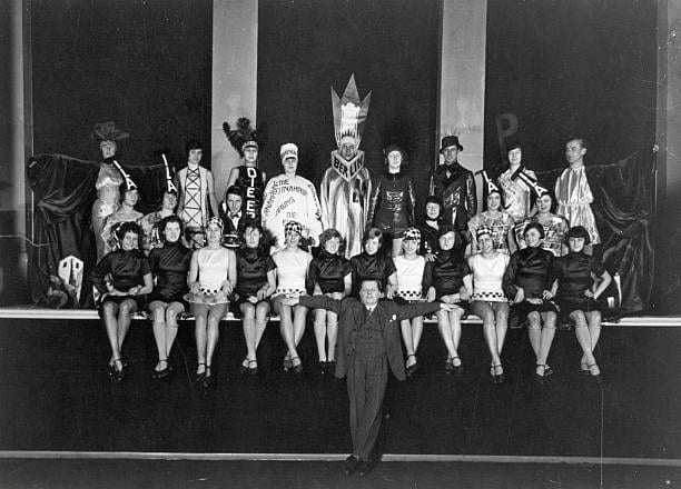 Ο Γερμανός καλλιτέχνης καμπαρέ και ηθοποιός [[#Willi Schaeffers [Βίλλι Σαίφερς]#]] στο κέντρο, μπροστά, μαζί με τους/τις ηθοποιούς της παράστασης Ausstellungsbilder [Εικόνες Έκθεσης] στο θέατρο Marmorsaal στο Βερολίνο, (1929).