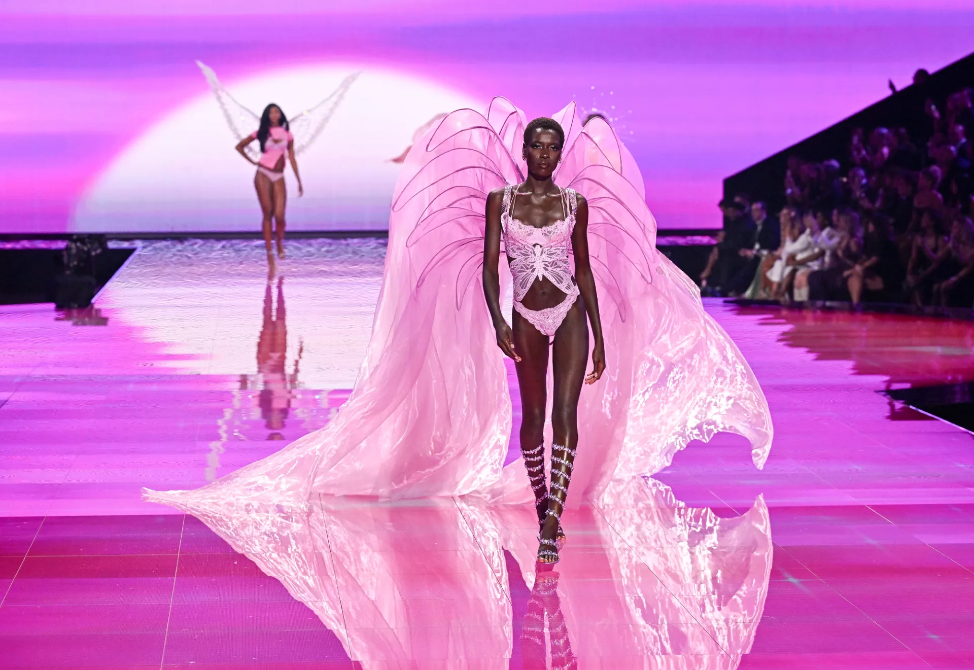 Η [[#Awar Odhiang [Αουάρ Οντιάνγκ]#]] στην πασαρέλα του Victoria’s Secret Fashion Show στη Νέα Υόρκη, στις 15 Οκτωβρίου 2025. Με τα υπερμεγέθη φτερά, τον σκηνικό φωτισμό και το κοινό που περιβάλλει την πασαρέλα, η επίδειξη μετατρέπει την παρουσίαση εσωρούχων σε σόου μόδας, όπου η ενδυματολογία, η κίνηση, η μουσική και η ψηφιακή μετάδοση συγκροτούν ένα ενιαίο ψυχαγωγικό θέαμα.