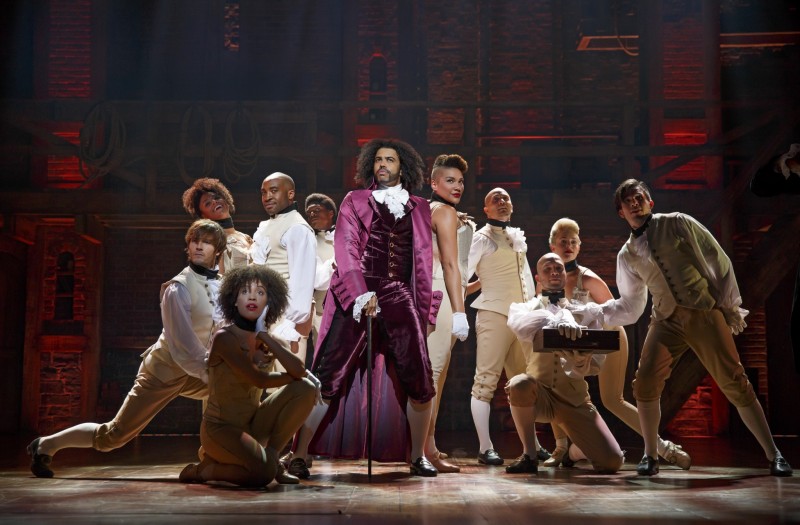 Ο Daveed Diggs [Νταβήντ Ντιγκς] ως Thomas Jefferson [Τόμας Τζέφερσον] με τον θίασο του&nbsp;Hamilton&nbsp;[Χάμιλτον] του Lin-Manuel Miranda [Λιν-Μανουέλ Μιράντα] (2015). Το βραβευμένο μιούζικαλ, που συνδυάζει χιπ-χοπ, ραπ και παραδοσιακές φόρμες του Μπρόντγουεϋ, αναθέτει τους ρόλους των λευκών ιδρυτών των ΗΠΑ σε ερμηνευτές και ερμηνεύτριες αφρικανικής ή λατινοαμερικανικής καταγωγής, πρακτική που πυροδότησε έντονη συζήτηση για τη φυλετικά συνειδητή διανομή [race-conscious casting] και την αναπαράσταση του μαύρου παρελθόντος. Φωτογραφία: Joan Marcus [Τζόαν Μάρκους].