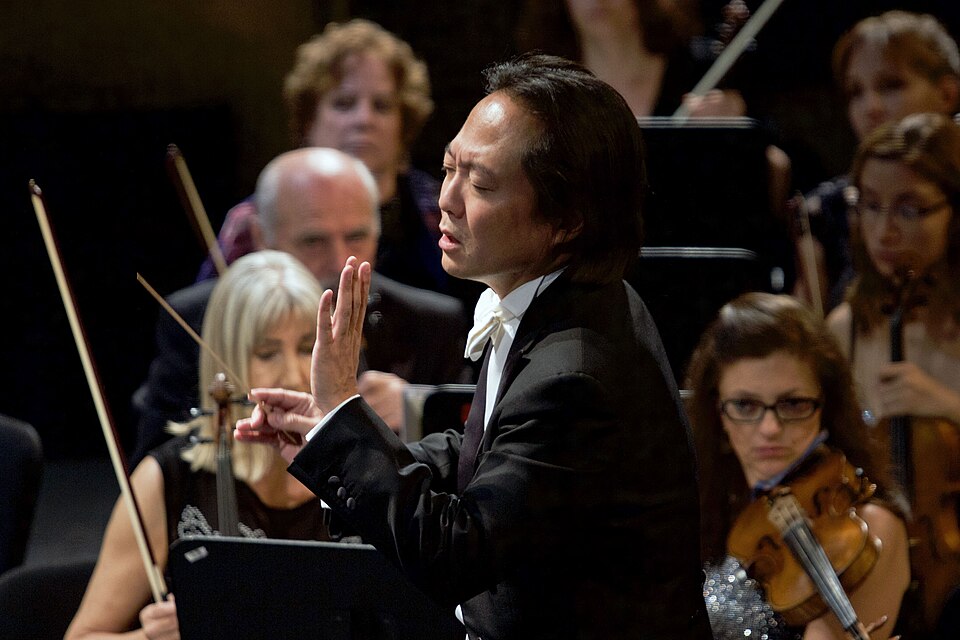 Ο [[#Scott Yoo [Σκοτ Γιου]#]] διευθύνει την [[#Orquesta Filarmónica de la Ciudad de México [Φιλαρμονική Ορχήστρα της Πόλης του Μεξικού]#]] στον εορτασμό της 38ης επετείου του συνόλου, στο Teatro de la Ciudad Esperanza Iris [Θέατρο της Πόλης Εσπεράνσα Ίρις], 28 Σεπτεμβρίου 2016, με συμμετοχή του Cuarteto Latinoamericano [Λατινοαμερικανικού Κουαρτέτου]. Η συγκεντρωμένη έκφραση του προσώπου και η ακριβής γλώσσα των χεριών του καλλιτεχνικού διευθυντή και πρώτου αρχιμουσικού του συνόλου αποτυπώνουν τη διπλή φύση της μουσικής διεύθυνσης ως τεχνικής χειρονομιακής επικοινωνίας και ταυτόχρονα ως ενσώματης ερμηνευτικής πράξης. Φωτογραφία: Milton Martínez [Μίλτον Μαρτίνες] / Secretaría de Cultura CDMX.