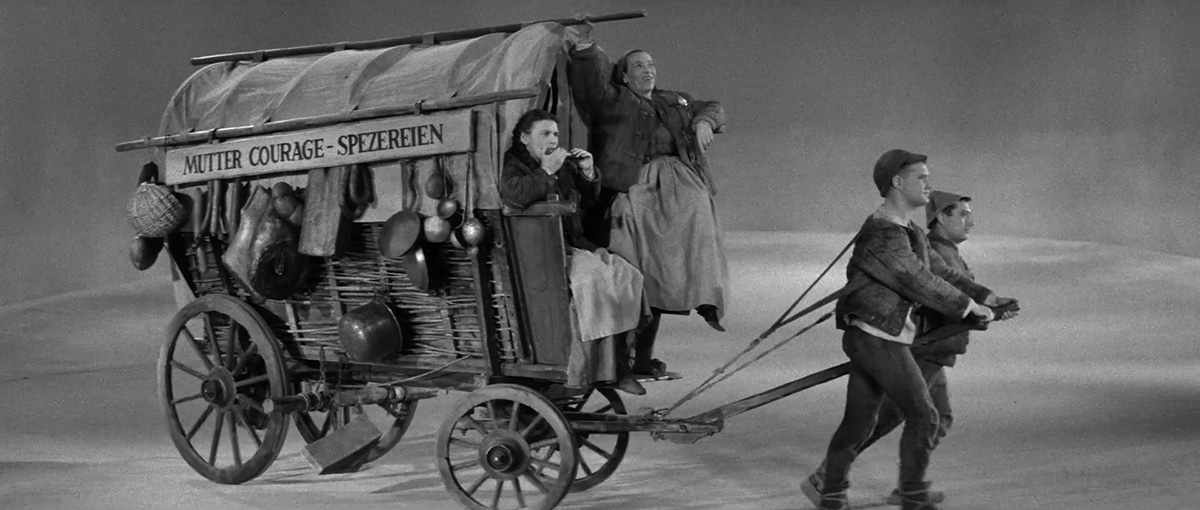 Στιγμιότυπο από την παράσταση Η μάνα Κουράγιο και τα παιδιά της [[[#Mutter Courage#]] und ihre Kinder] σε σκηνοθεσία του B. Brecht (1939), στην οποία ο πόλεμος δεν παρουσιάζεται ως αναπόφευκτη μοίρα, αλλά ως αποτέλεσμα συγκεκριμένων πολιτικών και οικονομικών συμφερόντων, τα οποία το κοινό καλείται να αναγνωρίσει κριτικά.