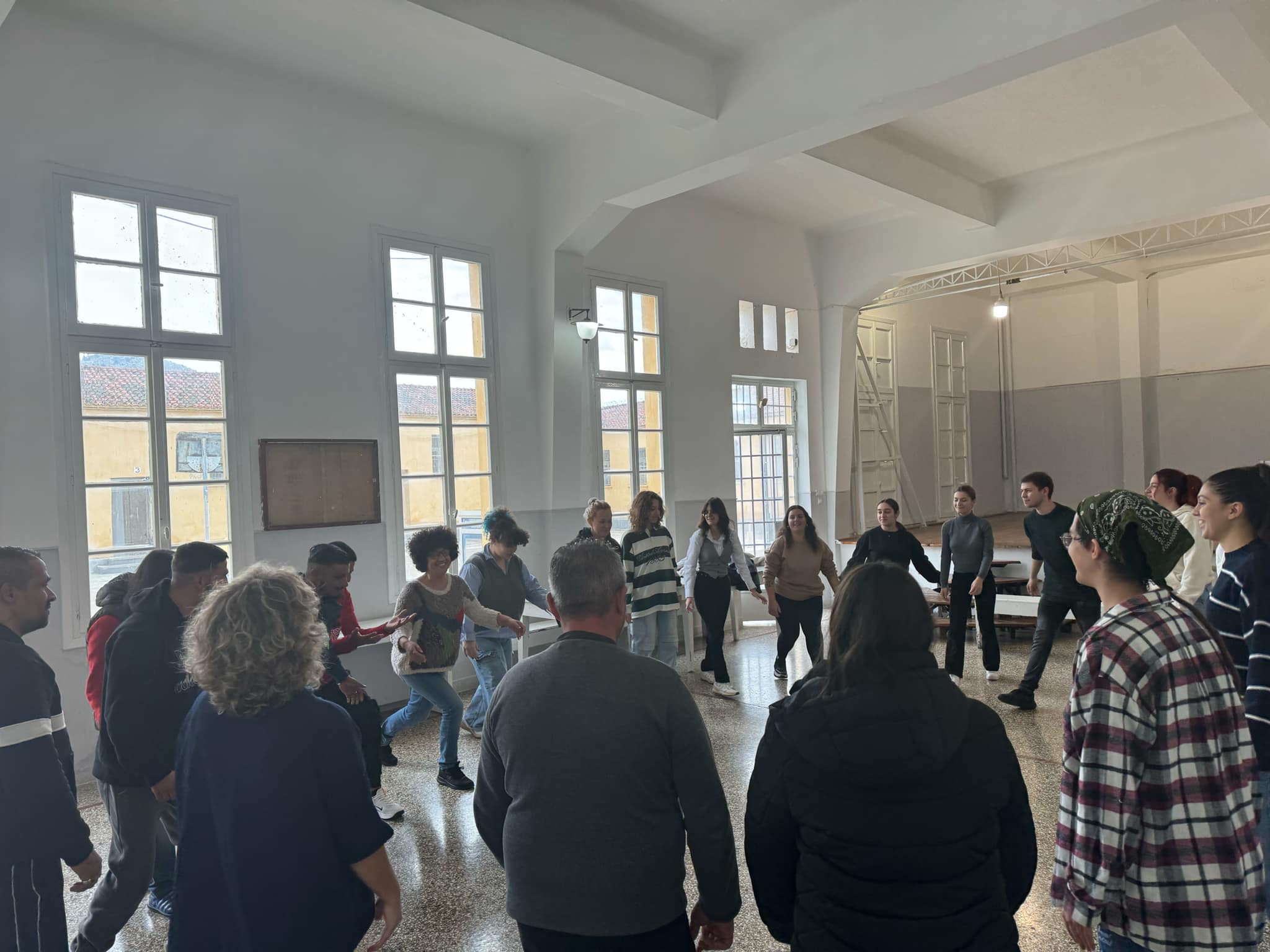 Η φωτογραφία από θεατροπαιδαγωγικό πρόγραμμα του [[#Τμήματος Θεατρικών Σπουδών#]] του [[#Πανεπιστημίου Πελοποννήσου#]] στις [[#Αγροτικές Φυλακές Ναυπλίου#]] με εμψυχώτρια την [[#Κατερίνα Κωστή#]] και τη συμμετοχή μικτής ομάδας φοιτητών/τριών και εγκλείστων. Οι παρεμβάσεις αυτές που βασίζονται σε τεχνικές του θεάτρου προσαρμοσμένες στις ανάγκες των κρατουμένων έχουν θετικά αποτελέσματα στην ψυχική τους διάθεση, στη μεταξύ τους σύνδεση, στην ενσώματη δραστηριοποίησή τους, στην απόλαυση της στιγμής και στη διάθεση να προσφέρουν κάτι στους άλλους.