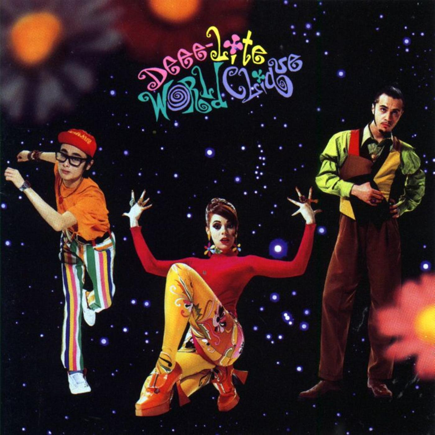 Εξώφυλλο του μουσικού άλμπουμ World Clique (1990) των [[#Deee-Lite#]], με τη [[#Lady Miss Kier [Λέιντυ Μις Κηρ]#]] σε ψηλούς πορτοκαλί κοθόρνους. Το τρίο εισήγαγε στην ποπ σκηνή των αρχών της δεκαετίας του 1990 μια ψυχεδελική, κουήρ αισθητική, ανασημασιοδοτώντας τον κόθορνο ως σύμβολο εορταστικής υπερβολής και κλαμπ κουλτούρας.