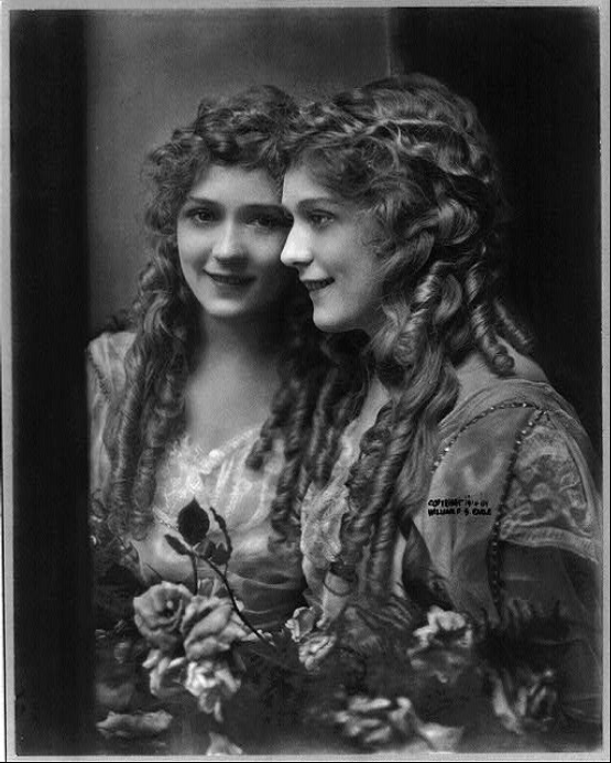 Mary Pickford [Μαίρη Πίκφορντ] (1892-1979), φωτογραφικό πορτραίτο με κατοπτρικό είδωλο, 10 Νοεμβρίου 1914, copyright William S. Earle [Ουίλλιαμ Σ. Ερλ] (Library of Congress, Prints and Photographs Division, Washington D.C.). Η Καναδοαμερικανίδα ηθοποιός, γνωστή ως «America's Sweetheart» [«η αγαπημένη της Αμερικής»] και συνιδρύτρια της εταιρείας United Artists, υπήρξε η κατεξοχήν ενσάρκωση της ενζενύ στον πρώιμο κινηματογράφο του βωβού, με τους χαρακτηριστικούς της ρόλους αθώων, ζωηρών και συναισθηματικών νεανίδων (συχνά με τους γνωστούς της βοστρύχους) να καθορίζουν την αμερικανική εικόνα της κινηματογραφικής νεότητας στη δεκαετία του 1910 και του 1920.