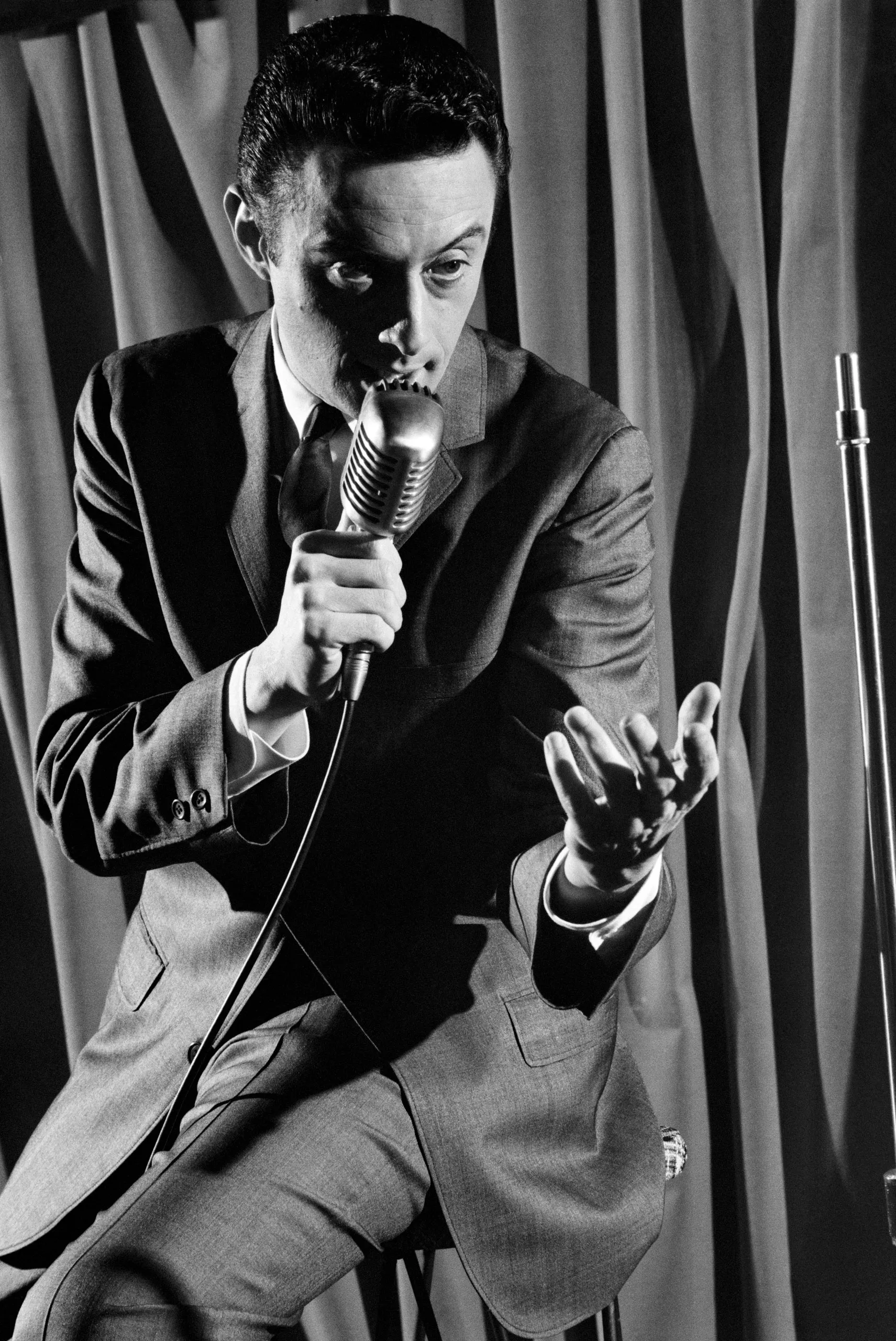 Ο Lenny Bruce [Λέννυ Μπρους] σε εμφάνιση στάντ-απ κωμωδίας, στις αρχές της δεκαετίας του 1960. Με τον αυτοσχεδιαστικό, «τζαζ» μονόλογό του και την καυστική κοινωνικοπολιτική σάτιρα, μετέτρεψε τη στάντ-απ κωμωδία σε πεδίο ελευθερίας του λόγου, προκαλώντας τα όρια της λογοκρισίας και οδηγούμενος σε επανειλημμένες συλλήψεις για «άσεμνη» επιτέλεση.