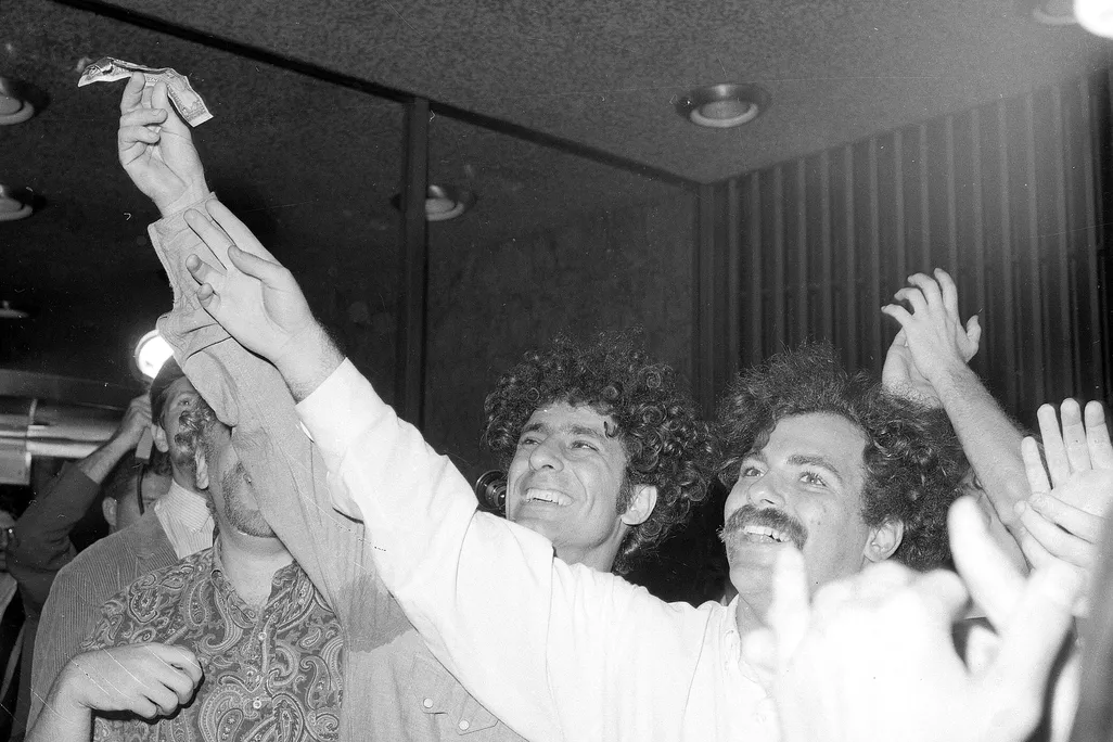 Στιγμιότυπο από τη θεατρική παρέμβαση που διοργάνωσε ο Abbie Hoffman στο Χρηματιστήριο της Νέας Υόρκης, κατά την οποία, μαζί με άλλους ακτιβιστές πέταξαν, έσκισαν και έκαψαν δεκάδες δεσμίδες δολαρίων, ασκώντας αιχμηρή πολιτική κριτική στην απληστία του καπιταλιστικού χρηματοπιστωτικού συστήματος. 