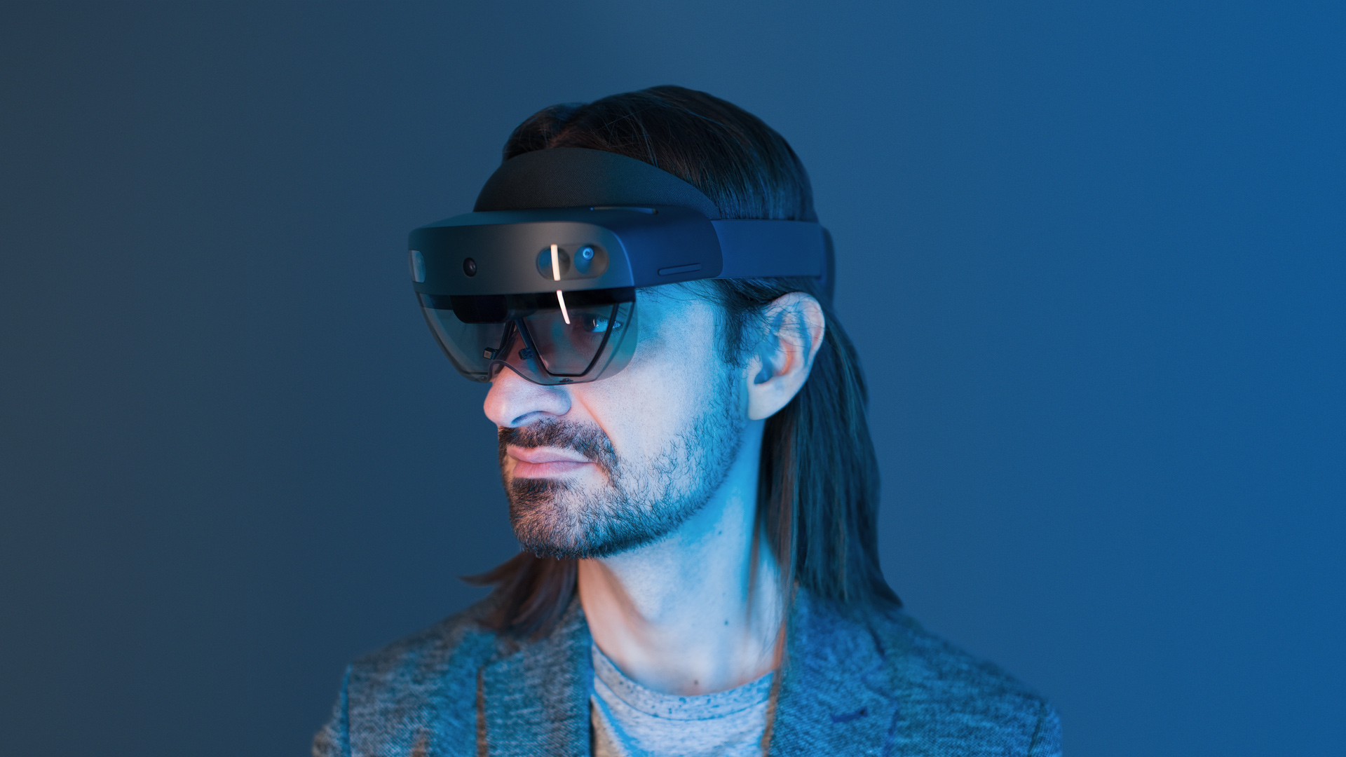 Συσκευή κεφαλής μικτής πραγματικότητας HoloLens 2 της Microsoft: οι αισθητήρες βάθους σαρώνουν τρισδιάστατα τον χώρο, ενώ οι ημιδιαφανείς οθόνες υπερθέτουν στο οπτικό πεδίο ψηφιακά αντικείμενα, τα οποία προσδένονται στις φυσικές επιφάνειες και αποκρίνονται σε χειρονομίες, φωνητικές εντολές και στην κατεύθυνση του βλέμματος.