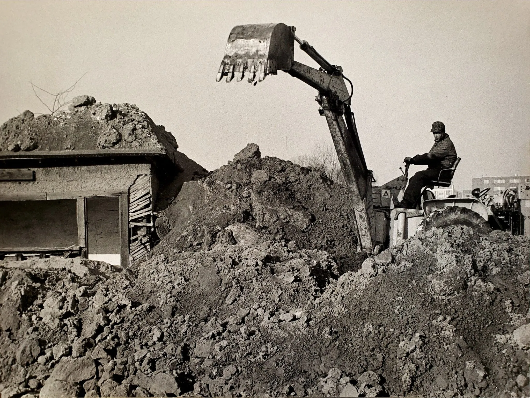 Robert Smithson, Partially Buried Woodshed [Μισοθαμμένη ξύλινη καλύβα], 1970, Kent State University, ΗΠΑ. Τον Ιανουάριου του 1970, ο Smithson ζητά από τον χειριστή ενός εκσκαφέα να αδειάσει τόσο χώμα πάνω στην εγκαταλελημμένη ξύλινη καλύβα που είχε ανακαλύψει στους χώρους της πανεπιστημιούπολης του Kent State University, ώστε να αρχίζει σταδιακά να καταρρέει η σκεπή της, δημιουργώντας έτσι ένα τοπίο εντροπίας. Λίγους μήνες μετά, στις 4 Μάιου του 1970, τέσσερις φοιτητές που συμμετείχαν σε διαδήλωση κατά του πολέμου του Βιετνάμ, δολοφονήθηκαν στην ίδια πανεπιστημιούπολη. Στους τοίχους της καλύβας γράφηκε ερήμην του Smithson, η ημερομηνία της δολοφονίας, κι έτσι το υπό κατάρρευση κτίριο, το οποίο εξαφανίστηκε εντελώς το 1984, συμβόλιζε και την κατάρρευση της αμερικανικής δημοκρατίας.