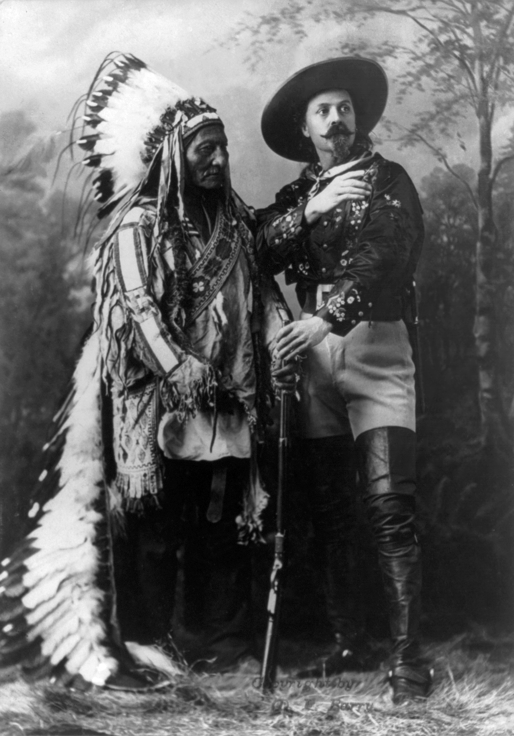 Ο William Frederick Cody, γνωστός ως Buffalo Bill, φωτογραφίζεται με τον ηγέτη των Λακότα Sitting Bull [Καθιστό Ταύρο] το 1885, με αμφότερους ενδεδυμένους με κοστούμια του Buffalo Bill's Wild West [Το σόου της Άγριας Δύσης του Μπάφαλο Μπιλ]. Η εικόνα δείχνει πώς ο Cody μετέτρεψε ιστορικά πρόσωπα, αφηγήσεις της Δύσης και επιτελεστικές δεξιότητες σε ένα διεθνώς περιοδεύον θέαμα.