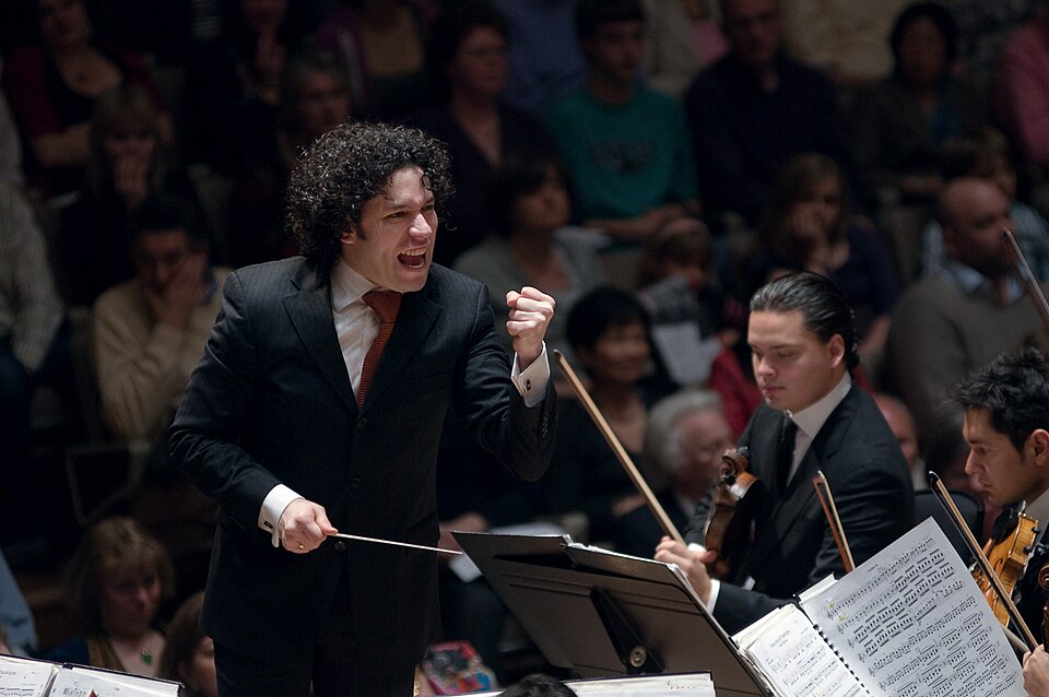Ο [[#Gustavo Dudamel [Γκουστάβο Ντουδαμέλ]#]] διευθύνει την [[#Simón Bolívar Youth Orchestra [Ορχήστρα νέων Σιμόν Μπολιβάρ]#]] στο Royal Festival Hall του Λονδίνου (2009). Η ορχήστρα αποτελεί τον εμβληματικότερο σχηματισμό του βενεζουελάνικου προγράμματος μουσικής εκπαίδευσης El Sistema.Φωτογραφία: [[#Rey Trombetta [Ρέυ Τρομπέτα]#]].