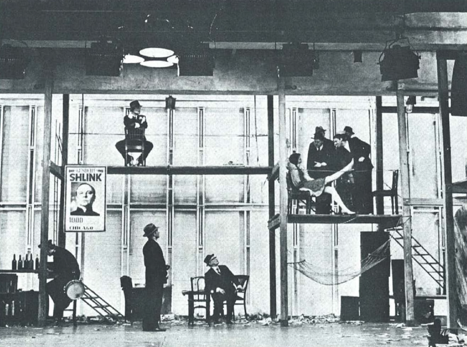 Το θεατρικό του Brecht Στη ζούγκλα των πόλεων [Im dickicht der städte/In the jungle of cities, 1923], που πρωτοπαίχτηκε στο Residenztheater [Θέατρο Ρέζιντενς] του Μονάχου, παρουσιάζει τον καπιταλισμό ως μια ανελέητη «ζούγκλα», όπου οι ανθρώπινες σχέσεις μετατρέπονται σε πεδίο πάλης για εξουσία. Στην φωτογραφία απεικονίζεται το σκηνικό του έργου, από την παράσταση του 1968, που ανέβηκε στην πειραματική σκηνή του Kammerspiele [Καμμερσπίλε] του Μονάχου, σε σκηνοθεσία του Γερμανού Peter Stein, με κεντρικό χώρο το μπαρ «Πικαντίλλυ» ["Piccadilly"], που συμβολίζει την παρακμή, την εκμετάλλευση και την αλλοτρίωση του ανθρώπου μέσα στον καπιταλιστικό κόσμο. &nbsp;