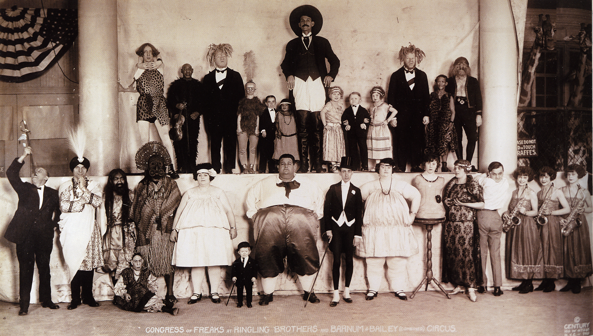 «Congress of Freaks» [«Σύναξη των ετερόμορφων»], ομαδική φωτογραφία των επιτελεστών και των επιτελεστριών του παράπλευρου θεάματος του τσίρκου Ringling Brothers and Barnum &amp; Bailey, 1924. Φωτογραφία: Edward J. Kelty [Έντουαρντ Τζ. Κέλτυ], Century Flashlight Photographers. Η διάταξη σε δύο επίπεδα και η ενδυματολογική διαφοροποίηση κατά κατηγορία, από το επίσημο ένδυμα έως τη «εξωτική» και τη «πρωτόγονη» αμφίεση, καθιστούν ορατή την ταξινόμηση των νούμερων. Ο Kelty φωτογράφισε συστηματικά τα αμερικανικά τσίρκα του Μεσοπολέμου με πανοραμική μηχανή και οι ετήσιες ομαδικές λήψεις του αποτελούν το πληρέστερο οπτικό αρχείο του είδους. 