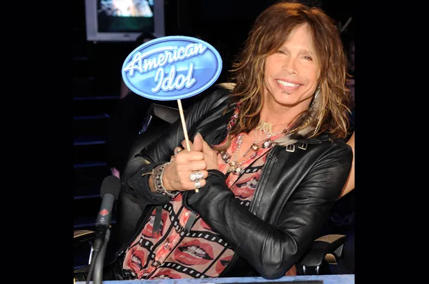Ο [[#Steven Tyler [Στήβεν Τάυλερ]#]], θρυλικός επικεφαλής τραγουδιστής των [[#Aerosmith#]] και ιστορική φωνή της σκληρής, σκανδαλιστικής αισθητικής του γκλαμ μέταλ, βρέθηκε στη θέση του κριτή του οικογενειακού τηλεοπτικού διαγωνισμού American Idol κατά τον δέκατο και ενδέκατο κύκλο του (2011–2012), σε μια συμβολική στιγμή όπου η άλλοτε «επικίνδυνη» περσόνα του ροκ σταρ αναβαπτίστηκε σε καλοπροαίρετο μέντορα της δημοφιλούς τηλεόρασης.