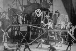 Στιγμιότυπο&nbsp;της παράστασης Ο μεγαλόψυχος κερατάς [Le cocu magnifique] του [[#Fernand Crommelynck [Φερνάν Κρομελάνκ]#]], κατά την οποία εφαρμόστηκε για πρώτη φορά η βιο-μηχανική μέθοδος υποκριτικής. Σκηνοθεσία: Βσέβολοντ Εμίλιεβιτς Μέγιερχολντ, σκηνικά: [[#Λιουμπόβ Σεργκέεβνα&nbsp;Ποπόβα [Liubov Sergeevna Popova]#]], Μόσχα (1922).