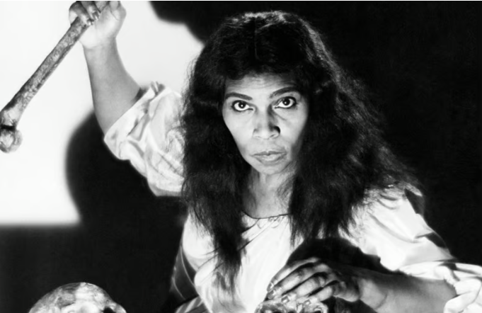 Η Μαριάν Άντερσον [Marian Anderson] στον ρόλο της Ουλρίκα στην όπερα του Τζουζέππε Βέρντι [Giuseppe Verdi]&nbsp;Ένας χορός μεταμφιεσμένων&nbsp;[Un ballo in maschera]. Η Άντερσον υπήρξε η πρώτη Αφροαμερικανίδα σολίστ που τραγούδησε στη Μητροπολιτική Όπερα της Νέας Υόρκης (1955), αποτελώντας εμβληματικό παράδειγμα της φωνητικής κατηγορίας κοντράλτο, με βαρύνουσα σημασία για τη διεθνή λυρική σκηνή και την ιστορία των παραστατικών τεχνών του 20ού αιώνα.