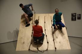 [[#Simone Forti [Σιμόνε Φόρτι]#]], Slant Board, 1961. Νέα Υόρκη, ΜοΜΑ, 2015. Η αξιοποίηση από τη Forti των καθημερινών κινήσεων —όπως το περπάτημα, το σκαρφάλωμα και η όρθια στάση των επιτελεστών που προσπαθούν να κινηθούν επάνω στην ξύλινη ράμπα— σε αντίθεση με τις συνήθως δεξιοτεχνικές χειρονομίες του κλασικού και μοντέρνου χορού, ανέτρεψε ριζικά τις παραδοσιακές αντιλήψεις για την έννοια και την εκτέλεση των χορογραφικών πρακτικών.