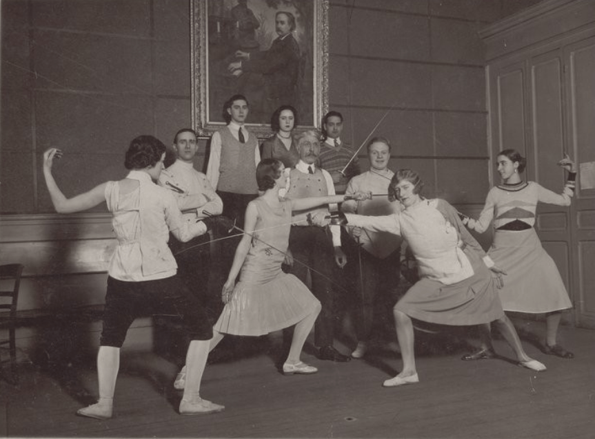Μάθημα ξιφασκίας στο Conservatoire national d'art dramatique του Παρισιού, ακαδημαϊκό έτος 1929-1930, με τον ξιφομάχο [[#Lucien Mérignac [Λυσιέν Μερινιάκ]#]], ο οποίος δίδαξε στη σχολή από το 1923 έως το 1933. Η ξιφασκία εντάχθηκε στο πρόγραμμα σπουδών ήδη από την ίδρυση της σχολής, το 1784, και αποτελεί χαρακτηριστικό δείγμα της σωματικής εκπαίδευσης που παρέχει η δραματική σχολή, παράλληλα με την απαγγελία και τη φωνητική αγωγή.